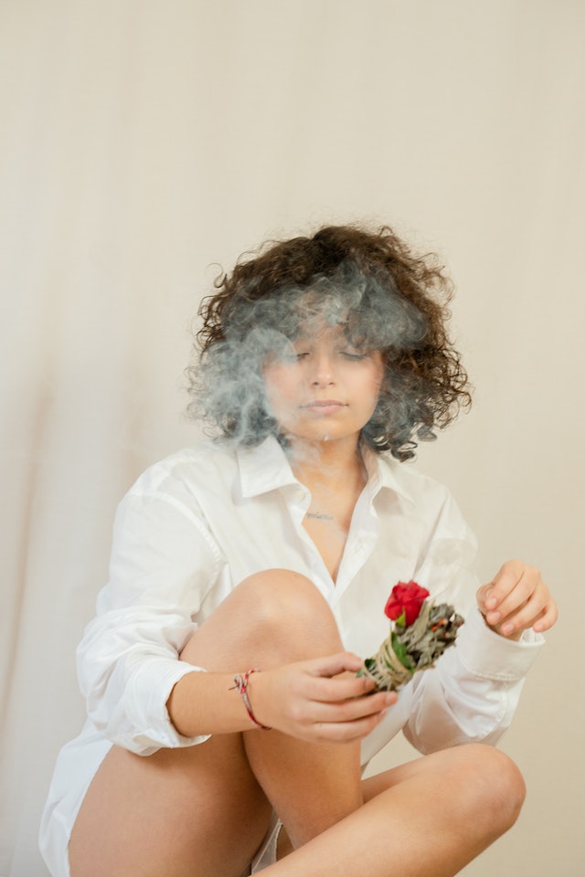 Woman Engulfed in Sage Smoke | Photo by Olha Ruskykh